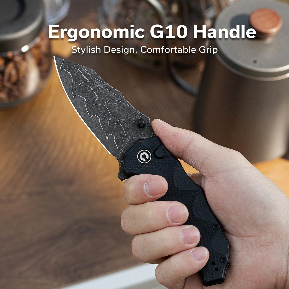 Hand gripping a black folding knife with a camo-patterned blade, highlighting an ergonomic G10 handle and comfortable grip.