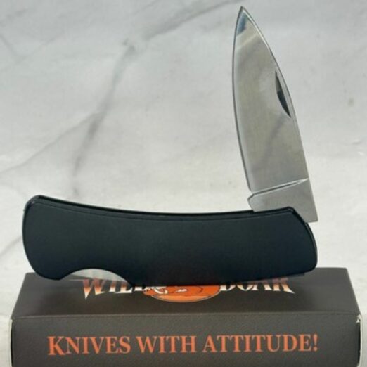 Black curved knife with a silver blade resting on a dark box that reads 'KNIVES WITH ATTITUDE!' on the side, product photo for a knife set