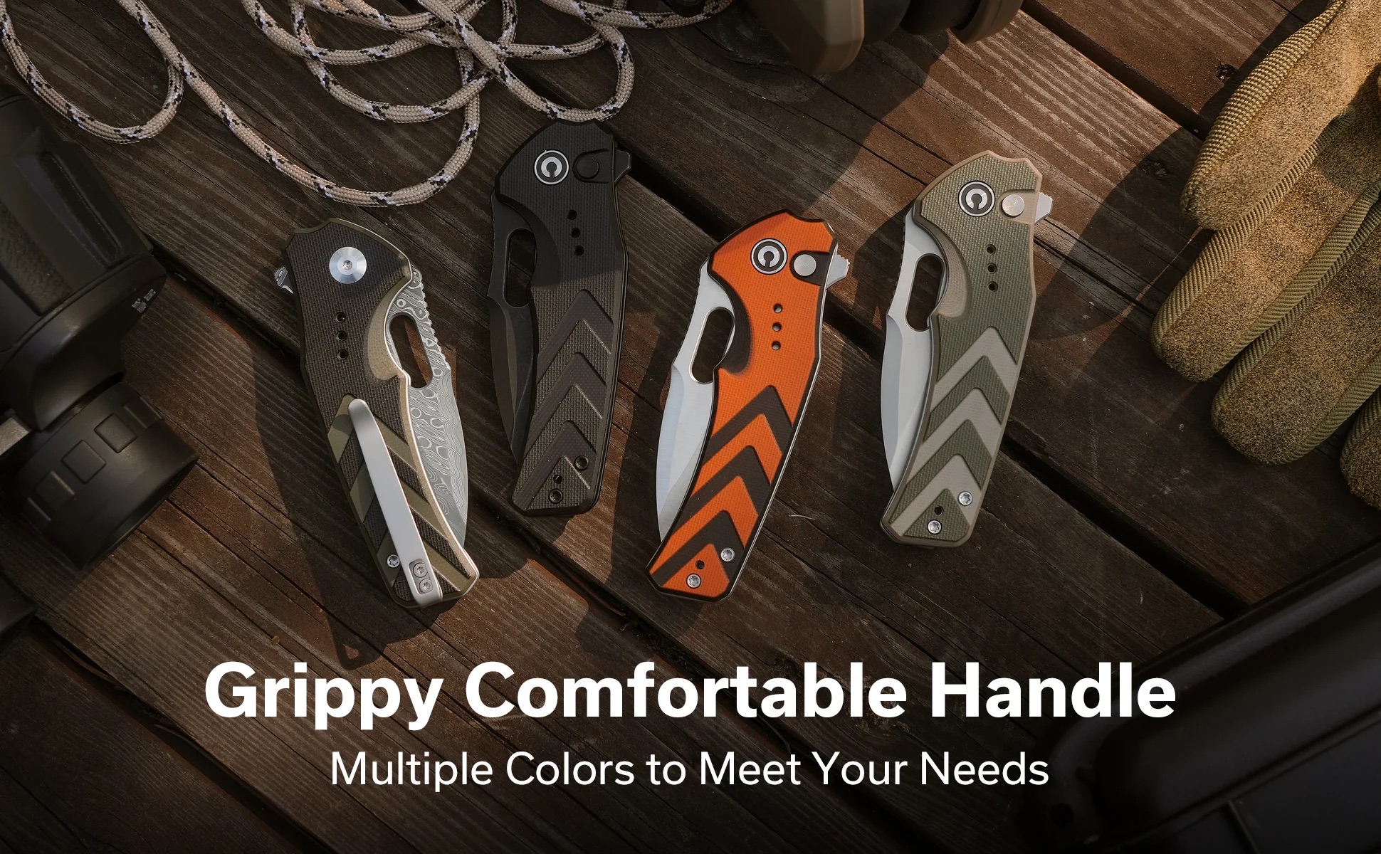 Set of five folding knives with textured handles in black, gray, orange, and tan on a wooden deck, with a paracord leash nearby.