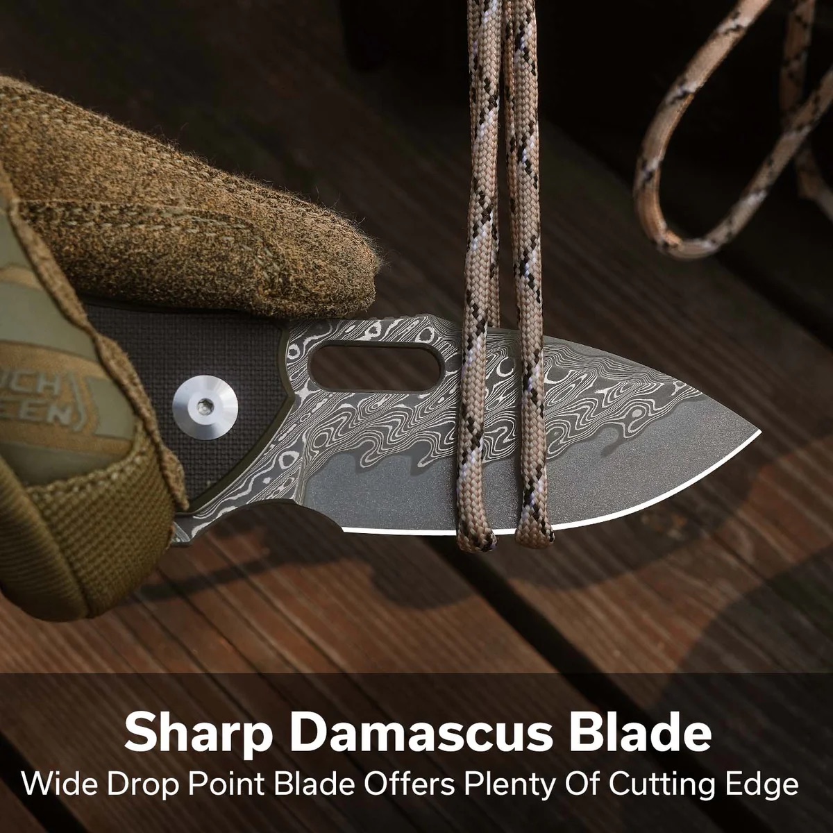 Close-up of a wide-drop-point Damascus blade knife with paracord and a tan sheath; overlay text reads 'Sharp Damascus Blade'.