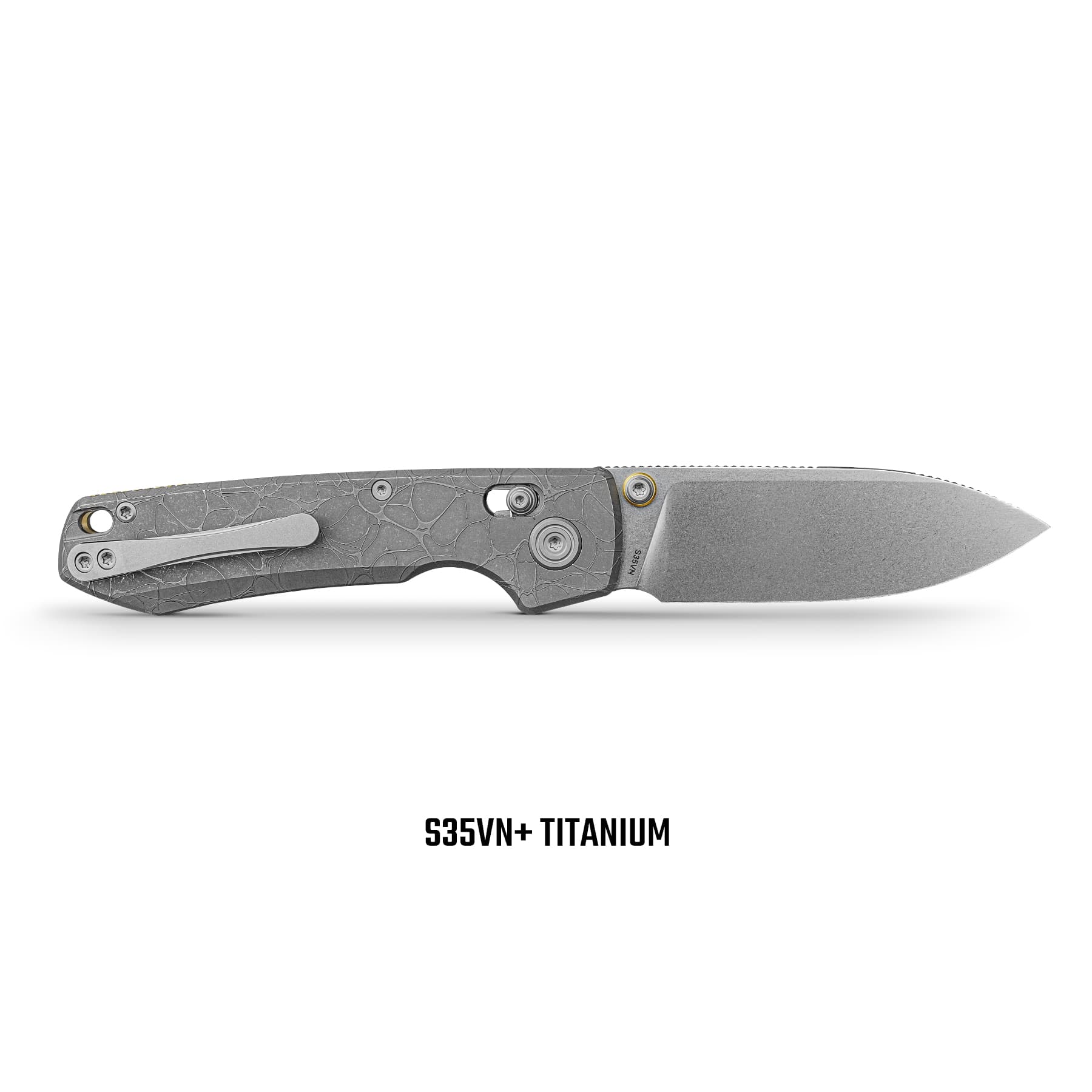 Close-up of a gray textured folding knife handle with screws, showing 'S35VN+ TITANIUM' text at bottom.
