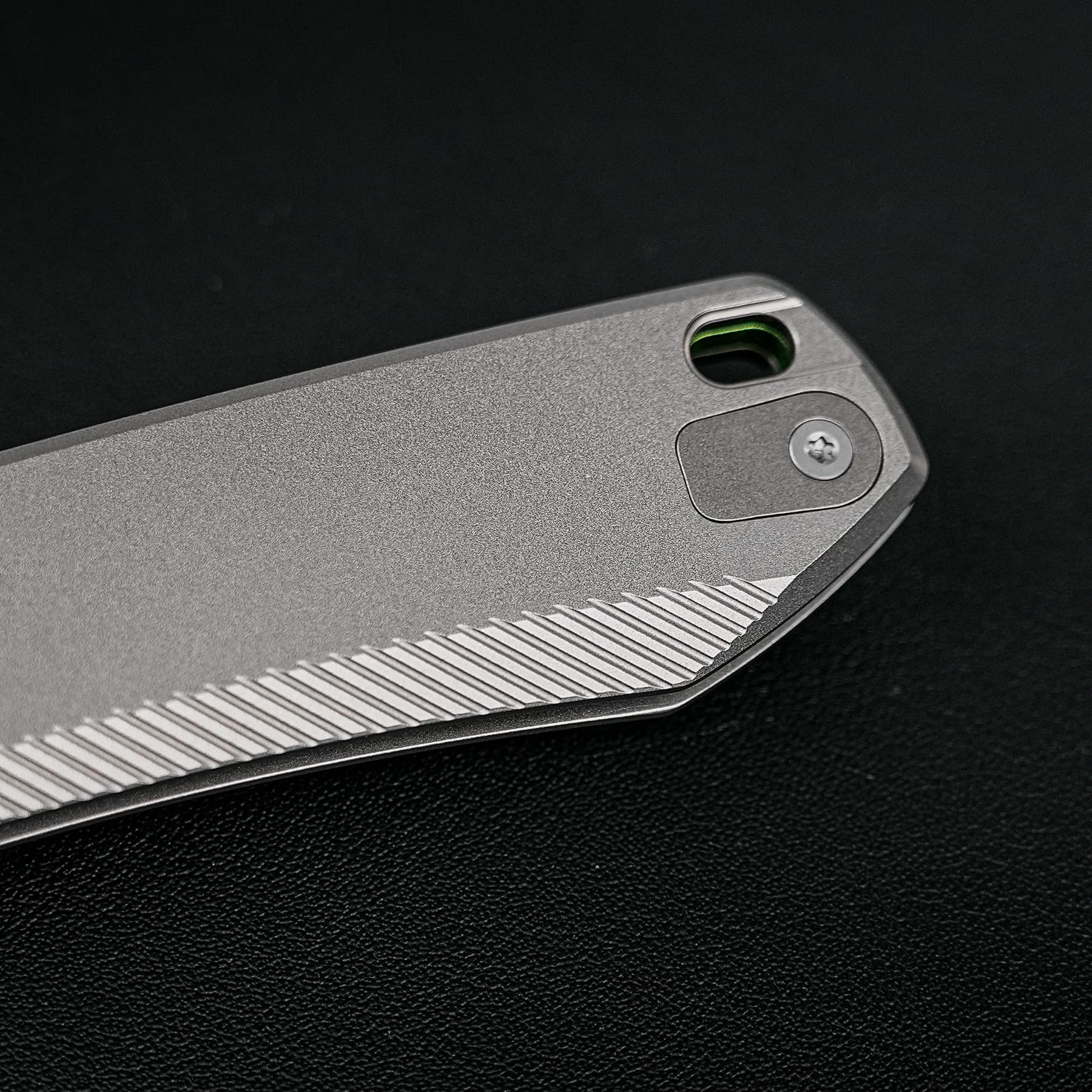 Close-up of a gray textured tool handle with a circular opening showing a green inner edge.