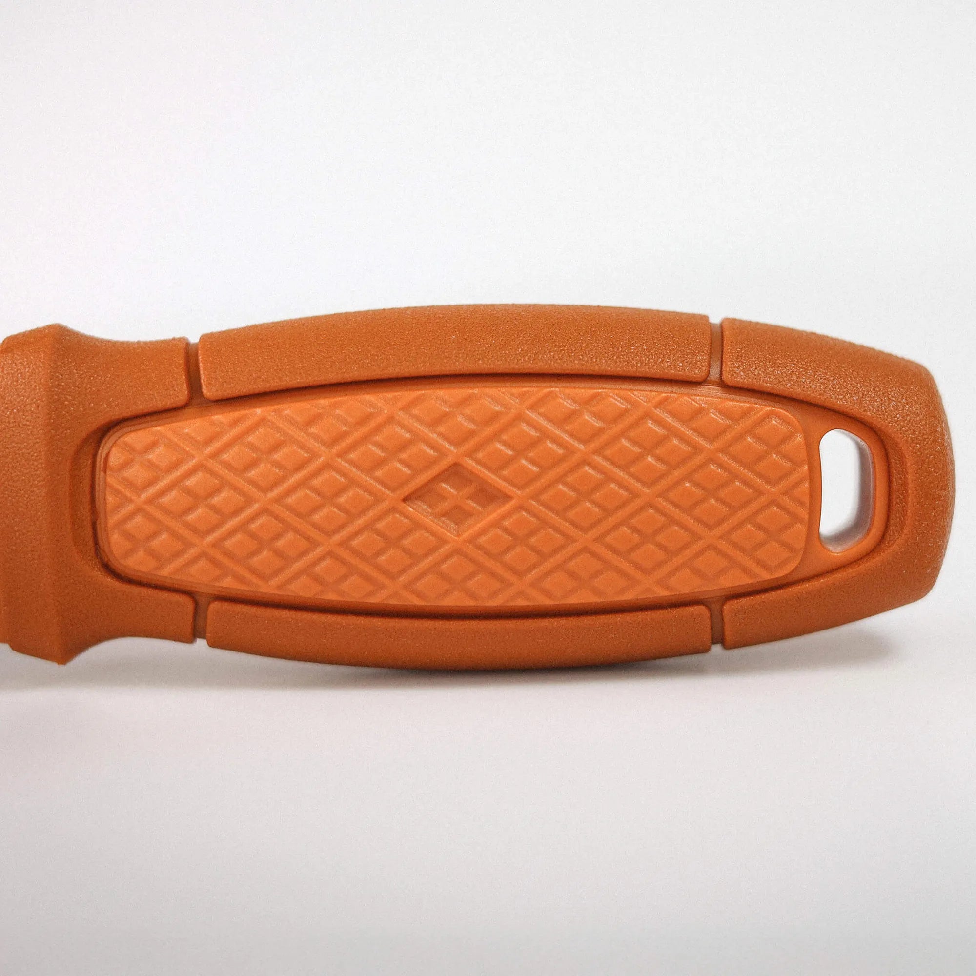 Close-up of an orange textured surface with a curved edge and a small cutout visible on the bottom right.