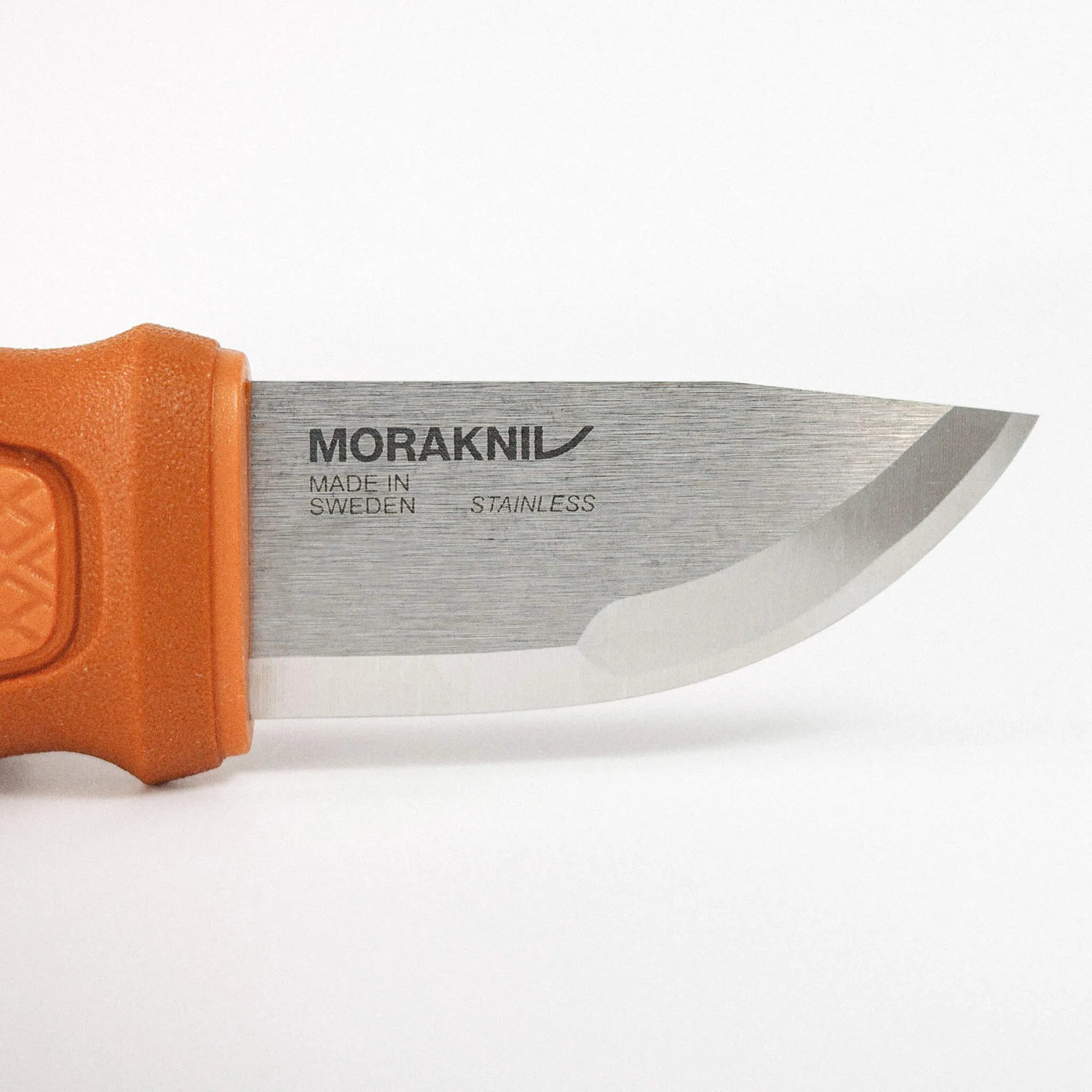 Close-up of an orange-handled Morakniv knife blade with branding visible on the steel (Made in Sweden, stainless).