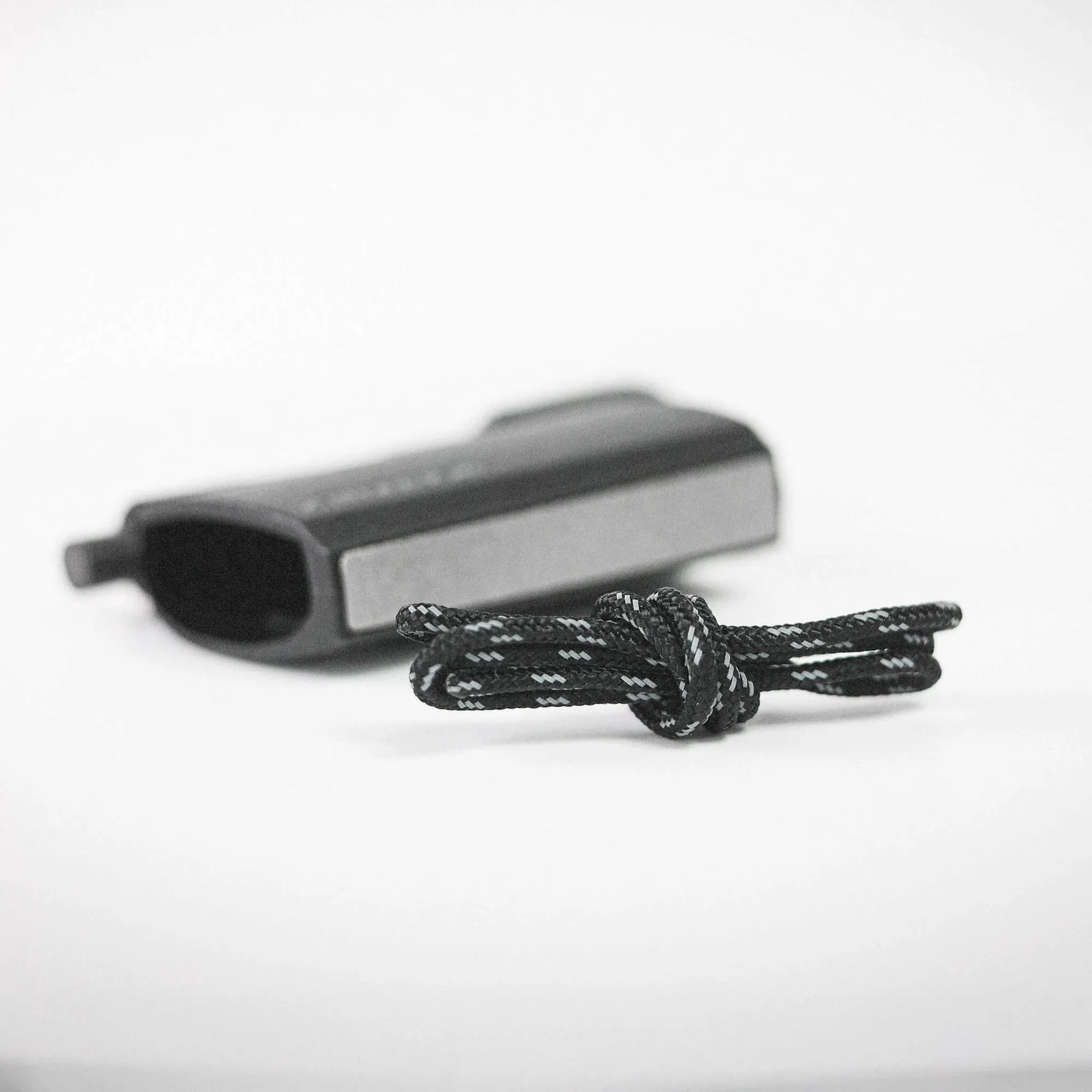 Close-up of a black handgun resting on a white surface.