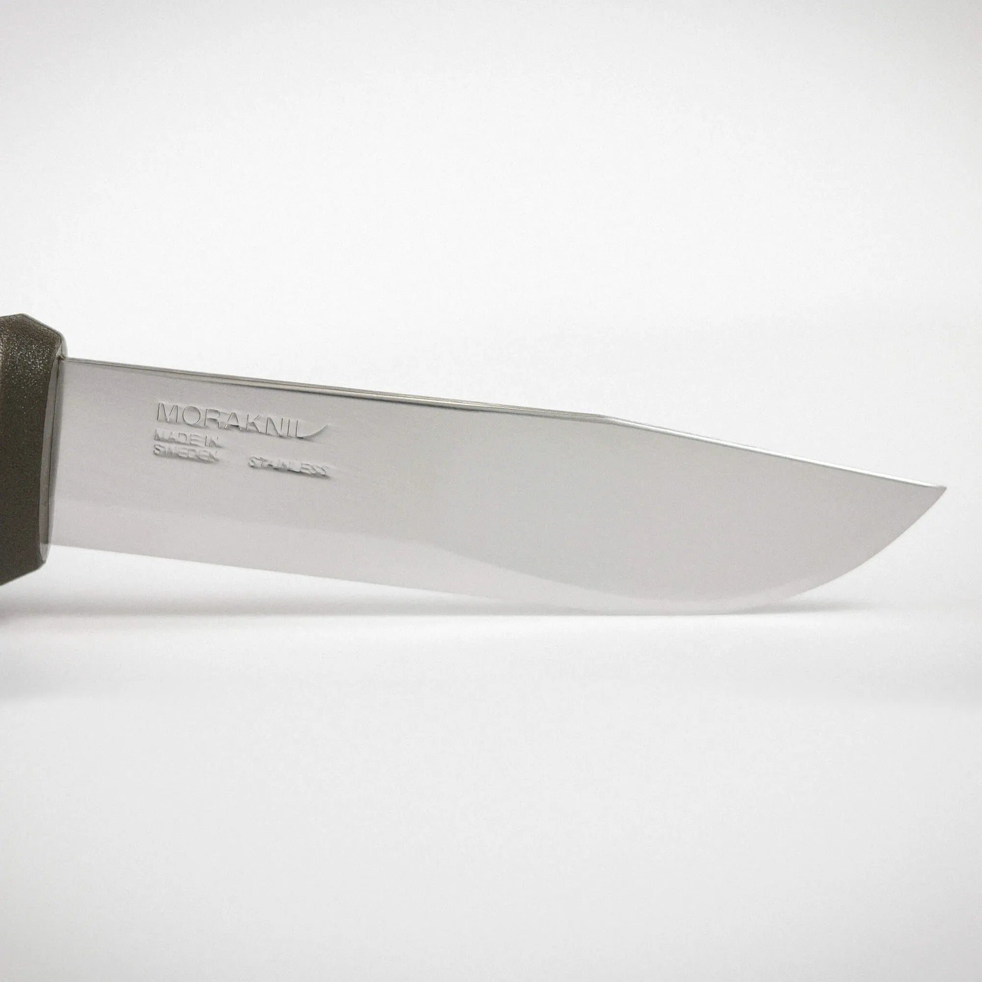 Close-up of a metal blade with embossed text, with a partial dark handle on the left and a light background.